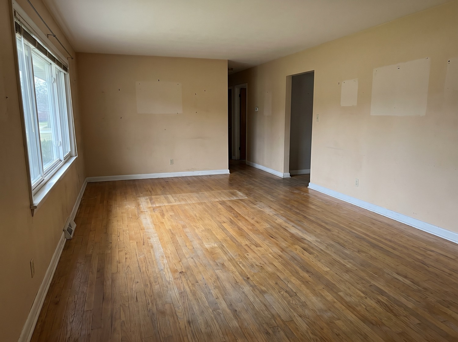 An emptied living room in an older Columbus-area house, bare hardwood floor and outlines on the wall where pictures hung