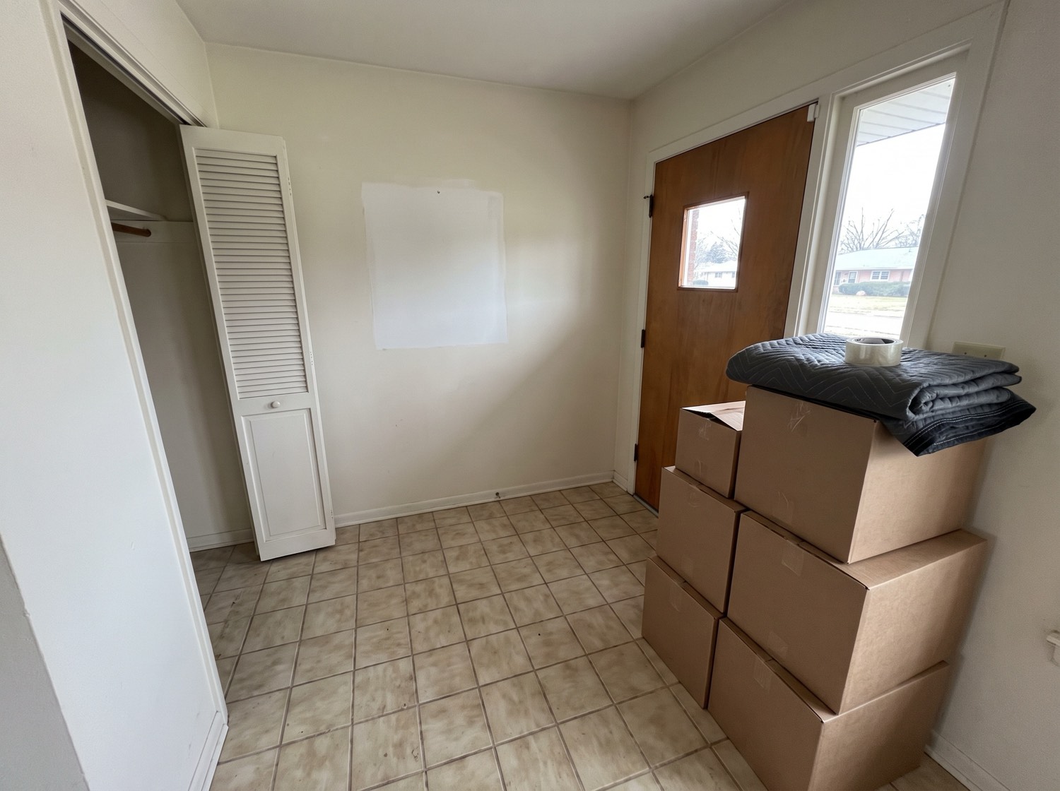 Moving boxes stacked neatly by the front door of a ranch home on move-out day